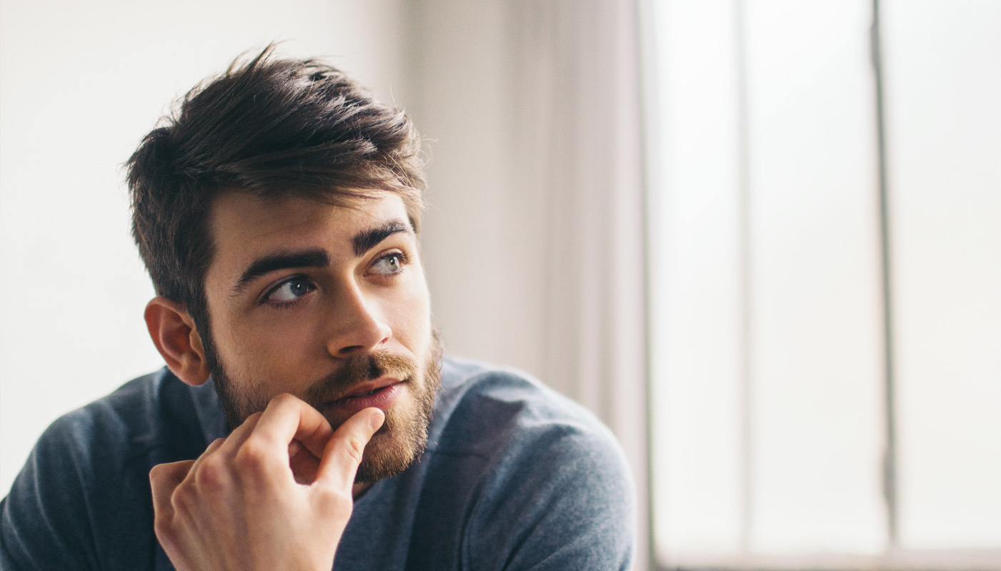 Partrait eines Mannes, der nachdenklich zur Seite sieht.